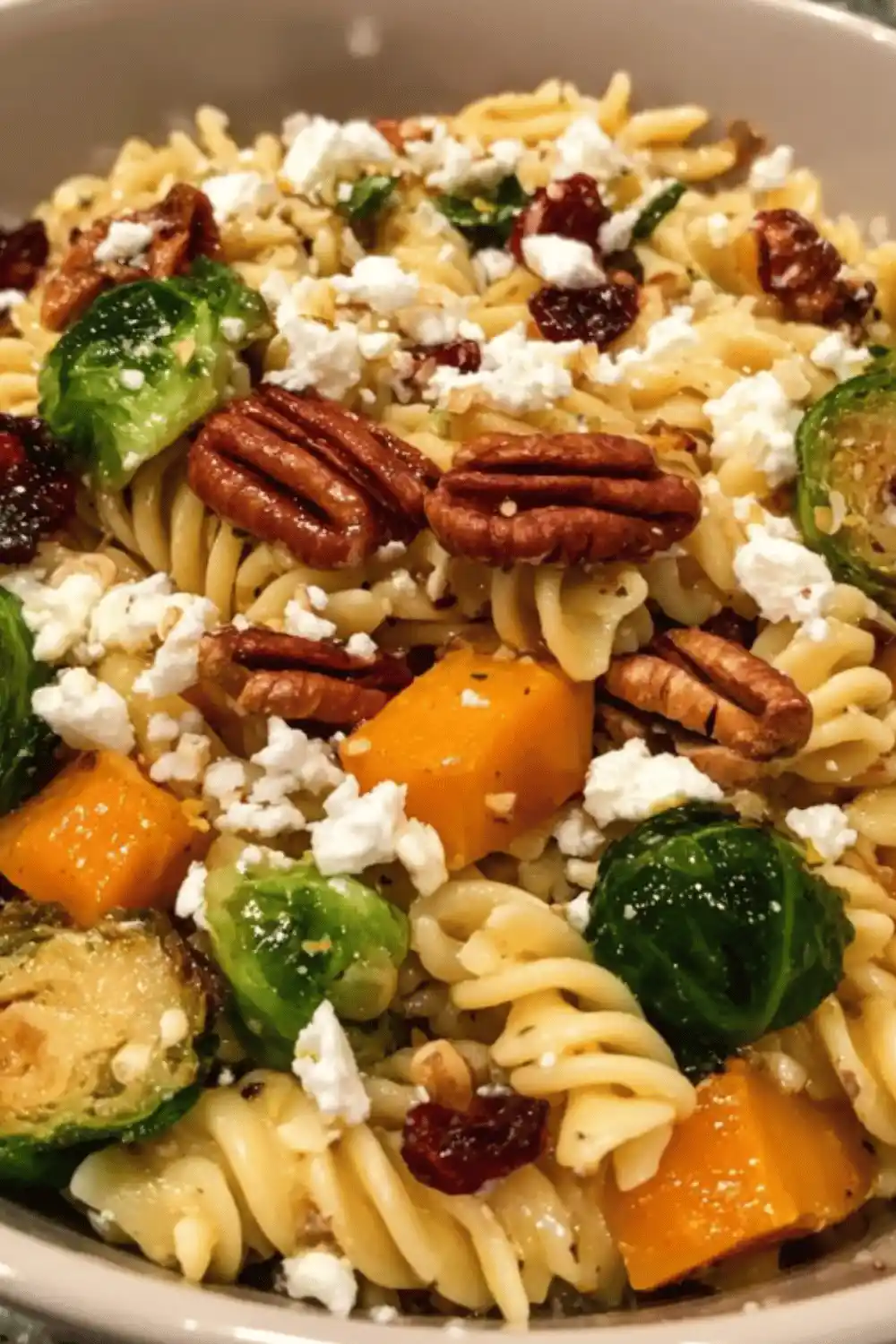 Fall Harvest Pasta Salad with roasted butternut squash, Brussels sprouts, apples, cranberries, and pecans tossed in maple Dijon vinaigrette - a colorful Thanksgiving side dish.