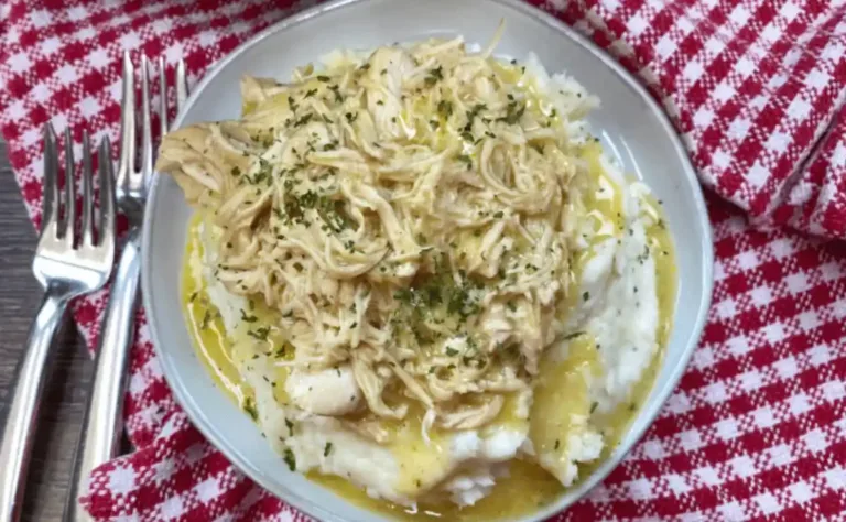 Bowl of slow cooker chicken and gravy with mashed potatoes and fresh parsley