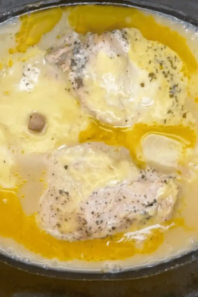 Shredded chicken in creamy gravy inside slow cooker ready to serve