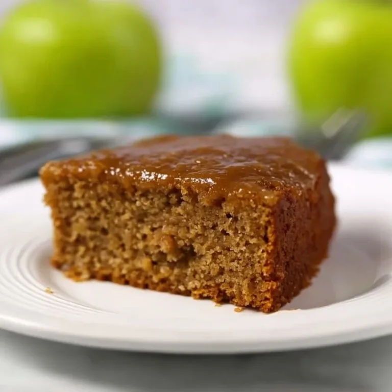 Slice of Old Fashioned Applesauce Spice Cake topped with spices and nuts.