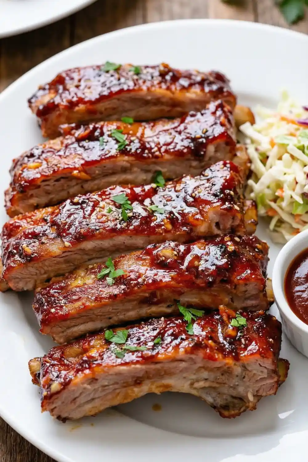 Oven baked barbecue ribs coated in rich, tangy sauce served on a platter.