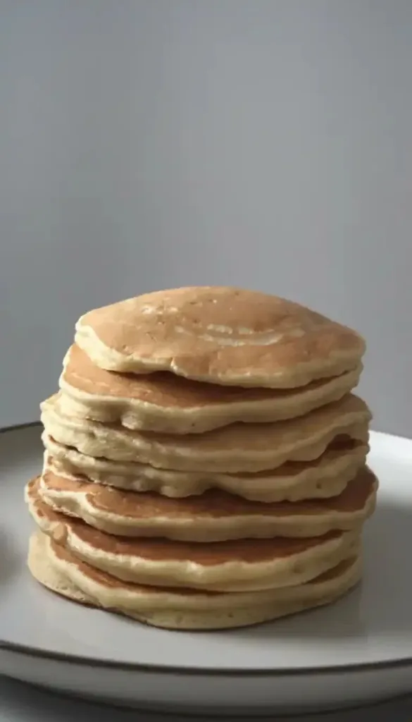 A bunch of ripe bananas on a wooden table, showcasing their bright yellow color.