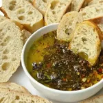 Bowl of homemade bread dipping oil with herbs and spices.