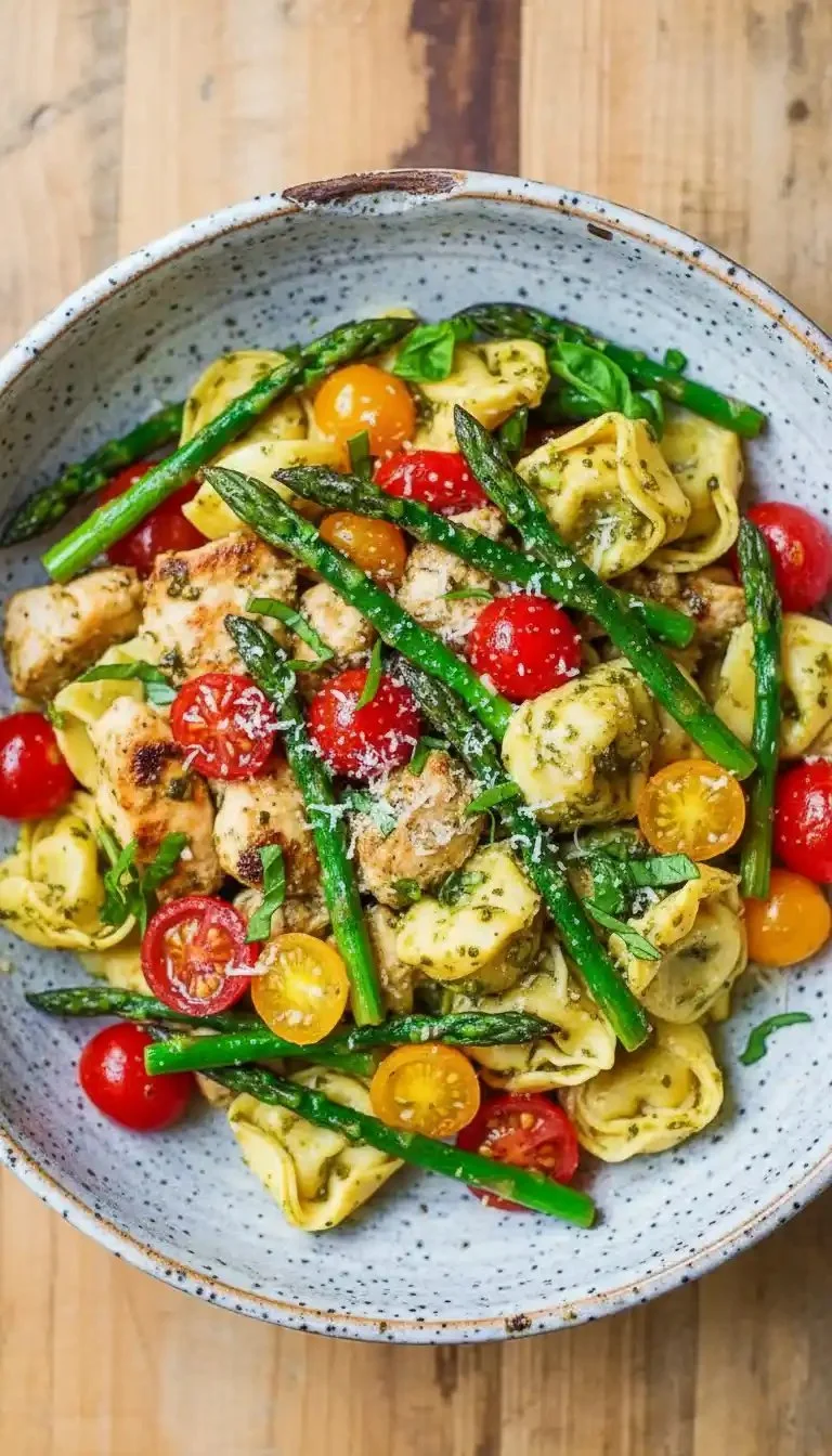 One-pan pesto chicken with tortellini and colorful veggies on a serving plate.