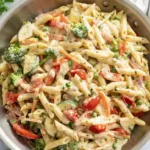 Colorful spring vegetable pasta dish with fresh ingredients and herbs.