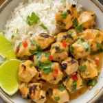 A plate of Thai Peanut Chicken garnished with green onions and served with rice
