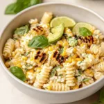 Juicy street corn pasta salad topped with fresh herbs and dressing.