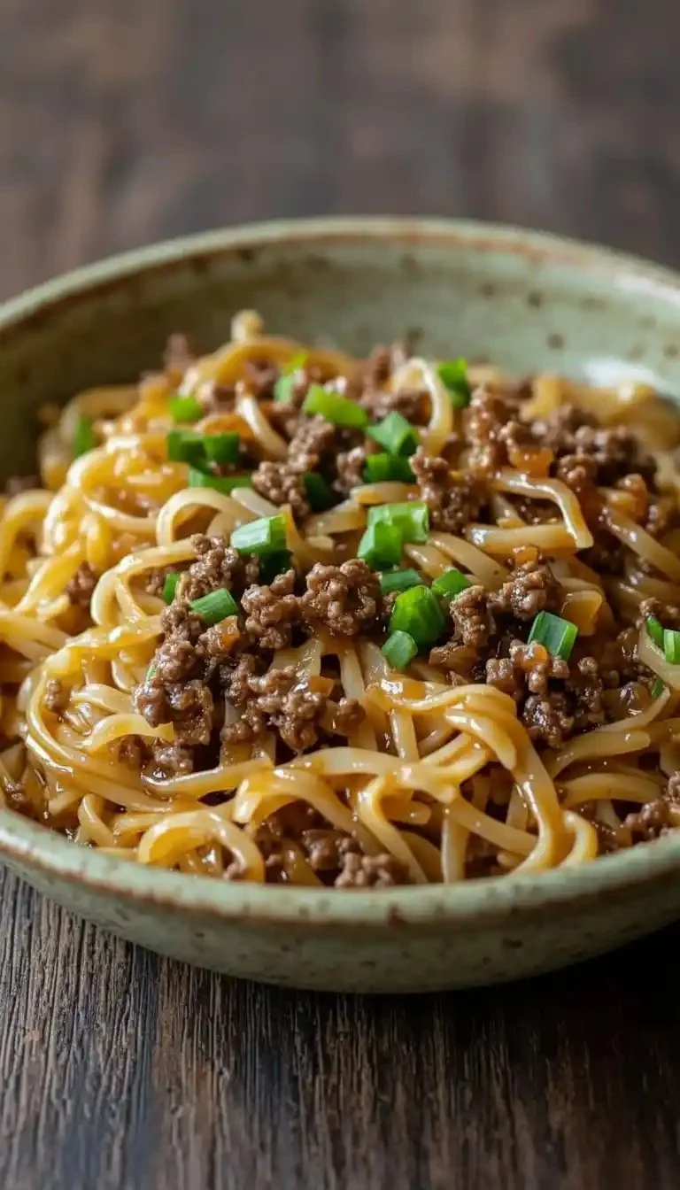 Mongolian Ground Beef Noodles served in a bowl with fresh vegetables.