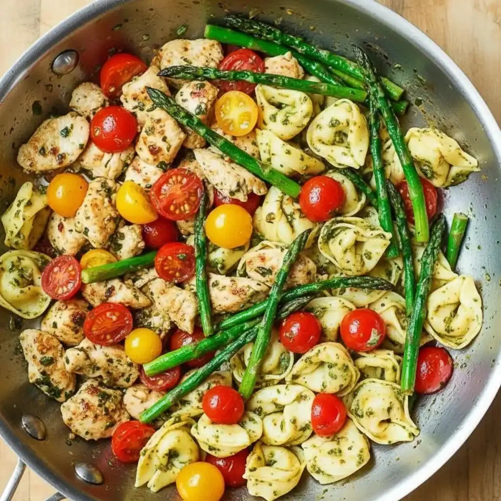 Pesto chicken served with tortellini and fresh veggies on a plate